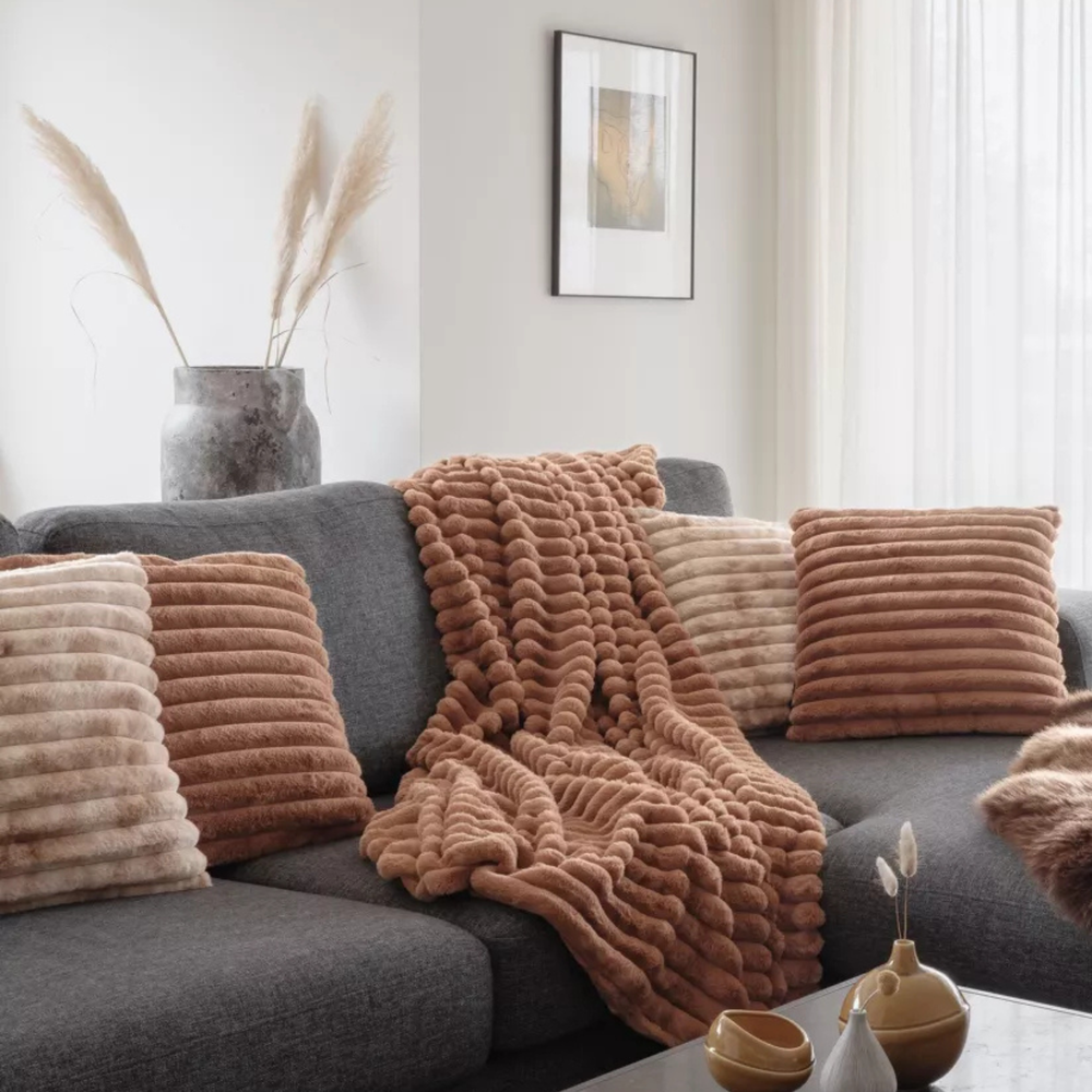 Pătură cognac așezată pe canapea în living modern